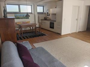a living room with a couch and a table and a kitchen at Wohnung mit Terrasse und eigenem Parkplatz in Nabburg
