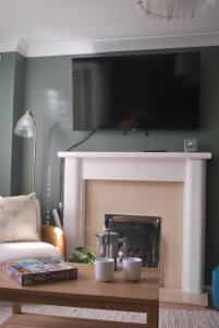 New - Beautiful Countryside Home في ستريتلي: غرفة معيشة مع موقد وتلفزيون فوقها