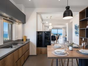 a kitchen and dining room with a table and chairs at Alectrona Living Crete, Villa Ãcro in Plataniás
