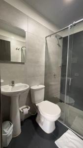 a bathroom with a toilet and a sink and a shower at Hotel Olam Confort in Villavicencio