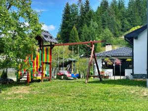 un parque infantil en un patio con un columpio en Bucovina Inn en Voronet