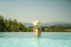 Una mujer con sombrero en una piscina en Agriturismo Il Sarale - Umbria, en Città di Castello