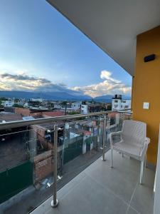 balcón con silla y vistas a la ciudad en Hotel Olam Confort, en Villavicencio