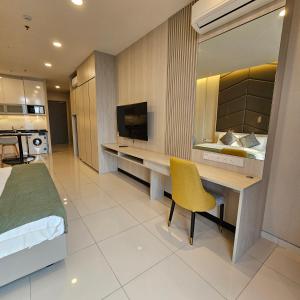 a bedroom with a bed and a desk with a television at Societe Suites By iHost Global in Kuala Lumpur