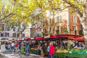 a group of people walking around a farmers market at Appartement loft terracotta in Manosque