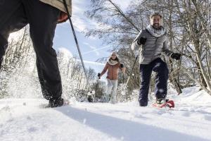 two people walking in the snow with a dog at Belambra Clubs Praz-sur-Arly - L'Alisier in Praz-sur-Arly