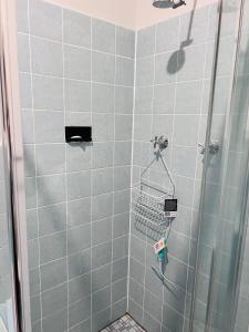 La salle de bains est pourvue d'une douche avec du carrelage gris. dans l'établissement Double bedroom in Sharehouse in Canberra and Queanbeyan, à Queanbeyan
