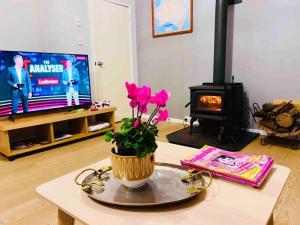 uma sala de estar com lareira e uma mesa com flores em Double bedroom in Sharehouse in Canberra and Queanbeyan em Queanbeyan
