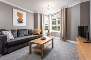 a living room with a couch and a tv at Elms Way No33 – Donnini Apartments in Ayr