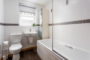 a white bathroom with a toilet and a sink at Elms Way No33 – Donnini Apartments in Ayr