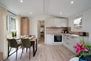 a kitchen and dining room with a table and chairs at Ostseecamp Ferienhaus "KleineDüne" in Scharbeutz