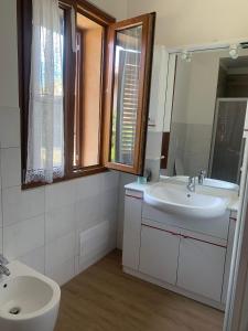 La salle de bains est pourvue d'un lavabo, de toilettes et d'un miroir. dans l'établissement Il BORGHETTO-1, à Grazzano Badoglio