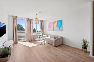 uma sala de estar com um sofá e uma mesa em Louises City Penthouse mit Panorama-Dachterasse em Friedrichshafen