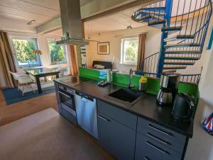 eine Küche mit einer Theke mit einer Spüle und einer Treppe in der Unterkunft "Buena Vista" Ashausen/Hamburg in Stelle
