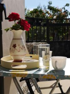 a table with a vase and a plate with a flower at Isthmus Cuddly Nest in Isthmia