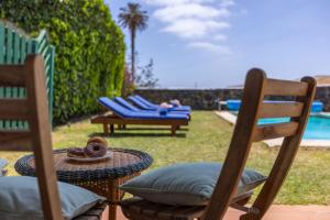 a table and chairs with a person laying on a couch at Casa El Barranco in Los Valles