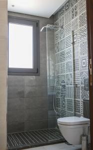 baño con ducha, aseo y puerta de cristal en Bolboa at Kennah Silver Palm, en El Cairo