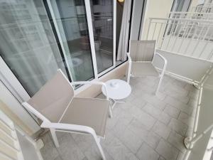 ビビオーネにあるHotel Astoriaのバルコニー(白い椅子、テーブル付)
