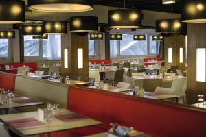 un restaurant avec des tables, des chaises et des lumières dans l'établissement Belambra Clubs Superbesse - Le Chambourguet, à Super-Besse
