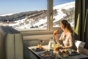 シュペール・ベスにあるBelambra Clubs Superbesse - Le Chambourguetの列車中で食べ物を食べる女