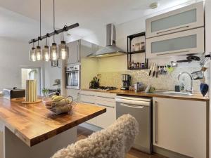 a kitchen with a counter with a bowl of fruit on it at ''Un secret Mâconnais'' de Miss.K Conciergerie in Mâcon +16 photos