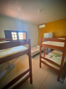 a room with two bunk beds and a table at Sol Hostel & Pousada Maragogi in Maragogi