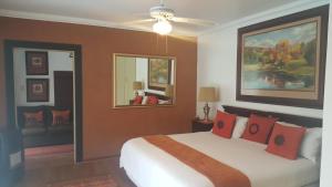 1 dormitorio con 1 cama grande con almohadas rojas en Lakeside Guesthouse, en Lichtenburg