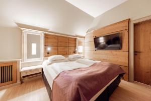 ein Schlafzimmer mit einem großen Bett und einem Flachbild-TV in der Unterkunft Avita Resort Bad Tatzmannsdorf in Bad Tatzmannsdorf