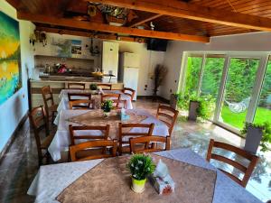 a restaurant with tables and chairs and a kitchen at Casa Maruska in Murighiol +28 photos