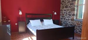 a bedroom with a bed with red walls at To Spitaki 