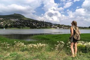 a woman standing in the grass near a lake at Belambra Clubs Superbesse - Le Chambourguet in Super Besse