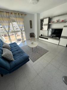 a living room with a blue couch and a table at Casa de Perlas in El Campello