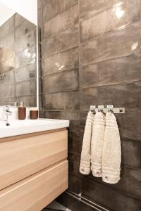 ein Badezimmer mit einem Waschbecken, einem Spiegel und Handtüchern in der Unterkunft Idyllic house in Old Rauma in Rauma