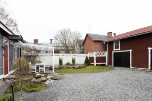 a backyard with a red house and a white fence at Idyllic house in Old Rauma in Rauma