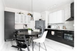 a black and white kitchen with a table and chairs at Idyllic house in Old Rauma in Rauma