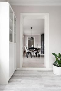 a white hallway with a table and a dining room at Idyllic house in Old Rauma in Rauma