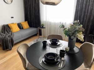 czarny stół z krzesłami i kanapa w salonie w obiekcie Cozy Apartment in Old Town Tartu w mieście Tartu