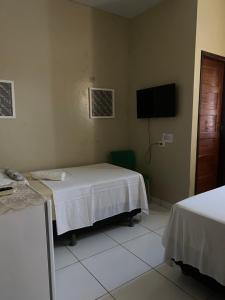 um quarto com uma cama e uma televisão de ecrã plano em Sol Hostel & Pousada Maragogi em Maragogi
