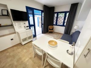 un soggiorno con tavolo e sedie bianchi di Apartamento privado en Bahía Feliz a Playa del Aguila