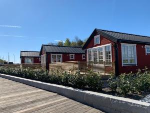 Casa con valla de madera y pasarela de madera en Lyxiga stugor med sjöutsikt, en Söderköping