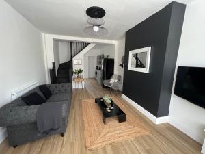 a living room with a couch and a tv at Modern 2 bedroom beach house in Cleethorpes