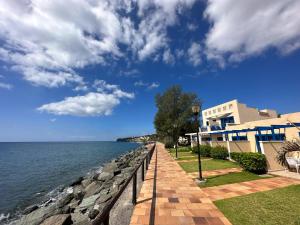 una passerella accanto all'acqua accanto a un edificio di Apartamento privado en Bahía Feliz a Playa del Aguila