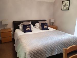 a bedroom with a large bed with blue pillows at Stonehenge Courtyard in Amesbury