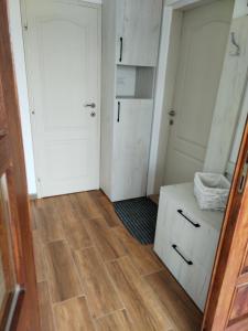 a room with white doors and a wooden floor at Apartmani planina Goč in Goč