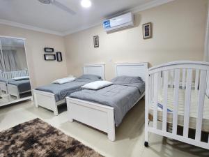 two twin beds in a room with two cribs at استراحه الليوان ALliwan Rak 1 in Ras al Khaimah