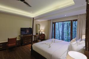 Punarnava Resort & Spa في دهرادون: غرفه فندقيه سرير وتلفزيون