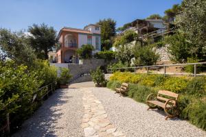 a walkway with two benches in front of a house at Villa Fedora Sea&Stars in Massa Lubrense