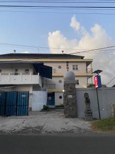 une maison blanche avec une porte bleue devant elle dans l'établissement Hotel Arda Bali, à Negara