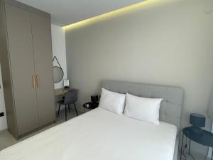 a bedroom with a white bed and a desk at Ladadika Luxury Apartment #4 in Thessaloniki