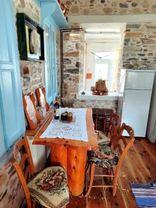 a kitchen with a table and chairs and a refrigerator at Kokkari Traditional House in Kokkari